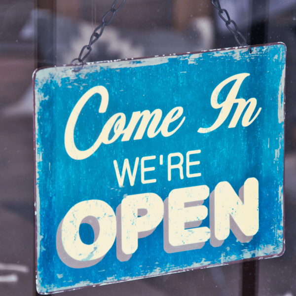 un panneau en métal avec écrit come in we're open